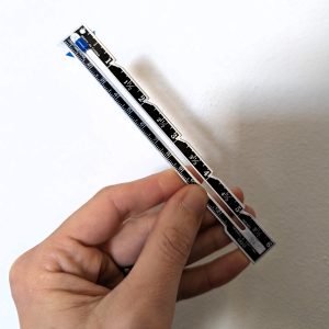 hand holding a small sewing gauge or caliper